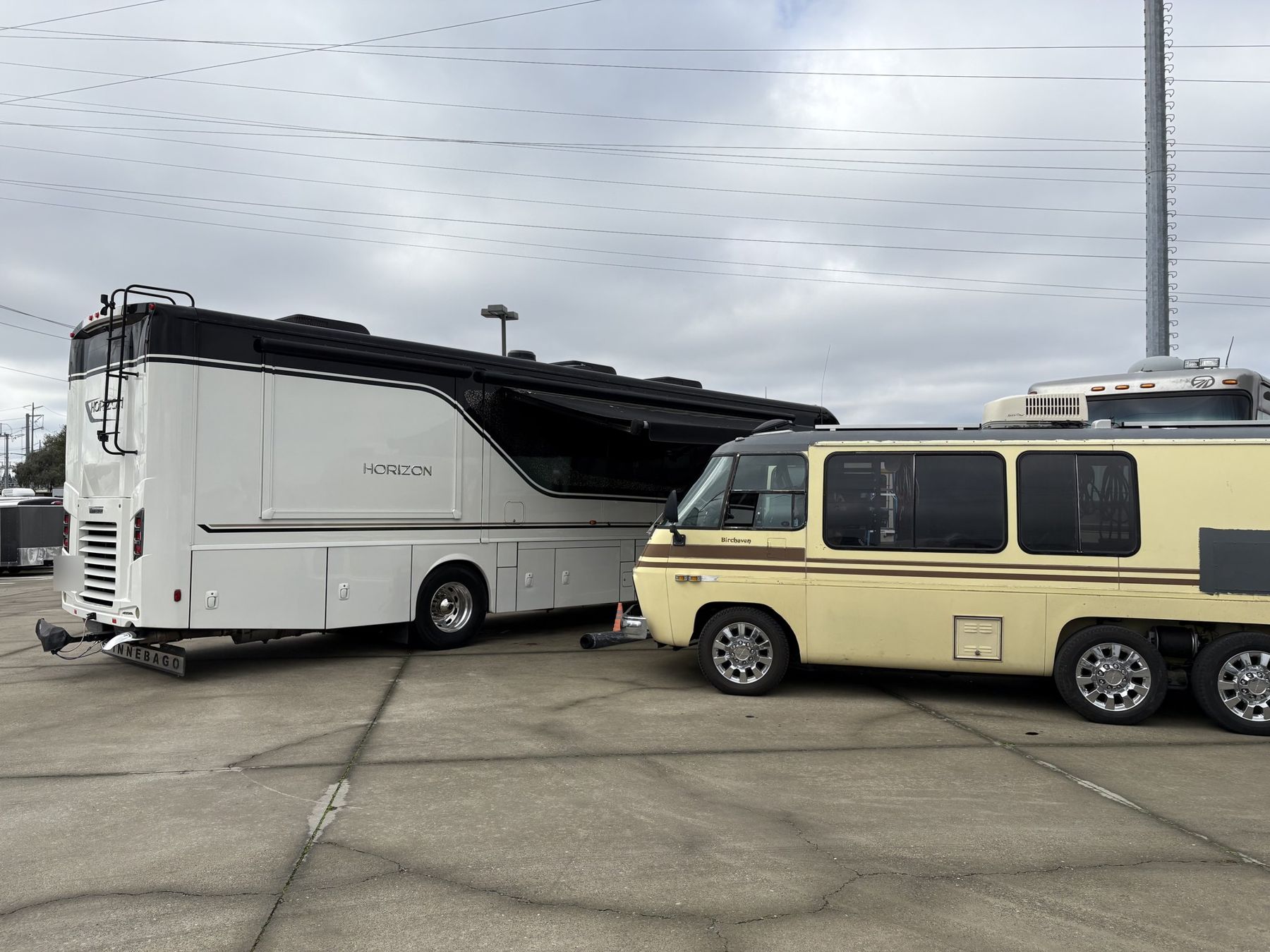 Eric's classic GMC motorhome parked beside a customer's Winnebago Horizon on a service call